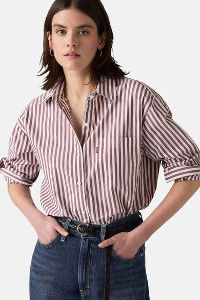 Roze en wit gestreept overhemd met lange mouwen van Levi's, gedragen met een high-waisted jeans en een gevlochten leren riem.