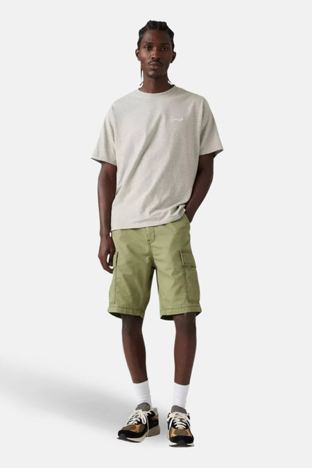 Korte groene cargo van Levi's, gedragen met een grijs T-shirt en meerkleurige sneakers.