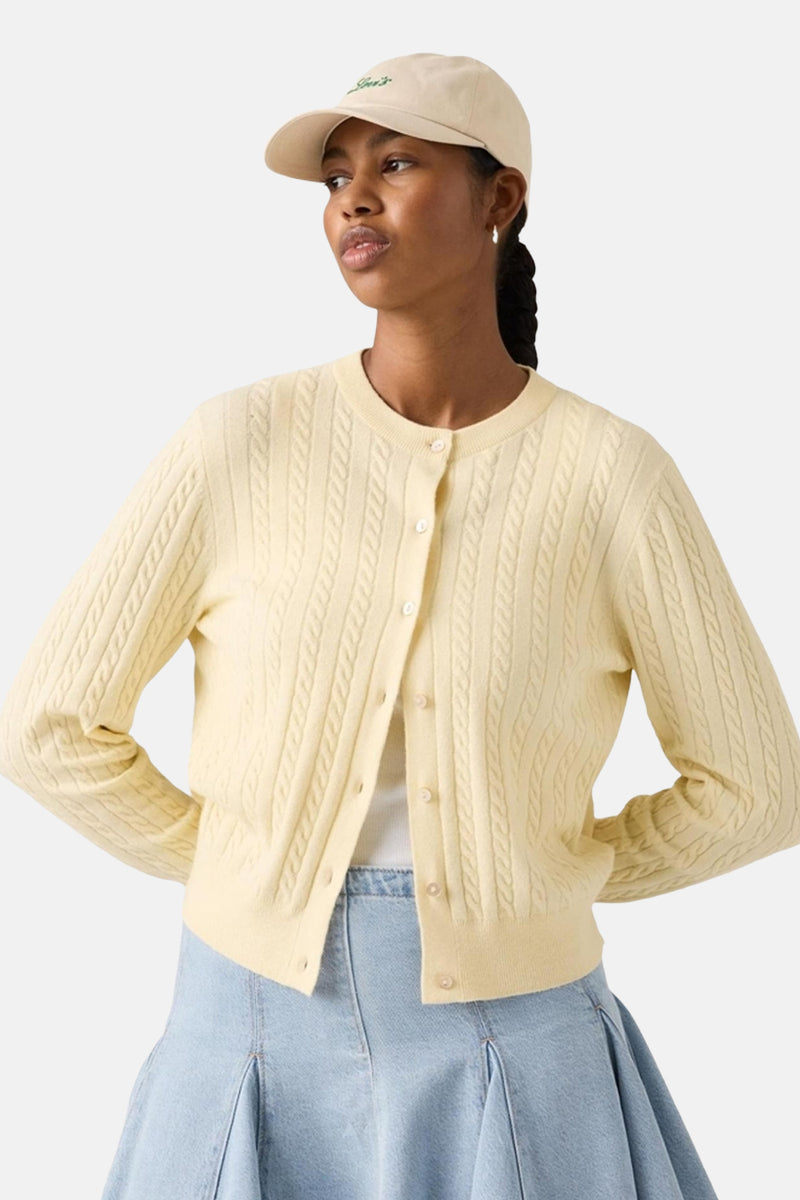 Lichtgele gilet van Levi's, met kabeldetails en gedragen met een spijkerrok.