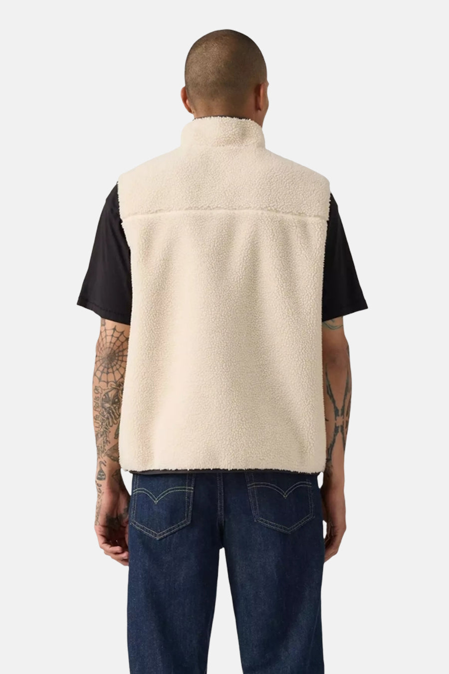 Veste sans manches beige de Levi's, avec une texture en polaire, portée sur un t-shirt noir et un jean bleu foncé.