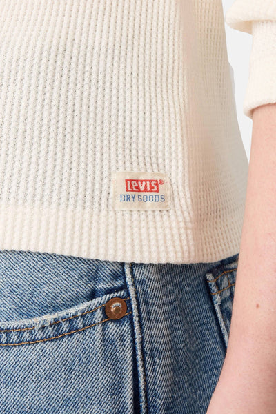 T-shirt blanc à manches longues de Levi's, en maille gaufrée, porté avec un jean taille haute.
