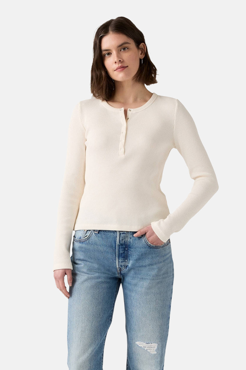 Wit T-shirt met lange mouwen van Levi's, gedragen met een lichtblauwe, gescheurde spijkerbroek.