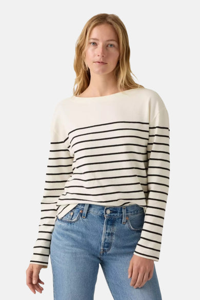 T-shirt à manches longues blanc de Levi's®, rayures horizontales noires, porté avec un jean bleu classique.
