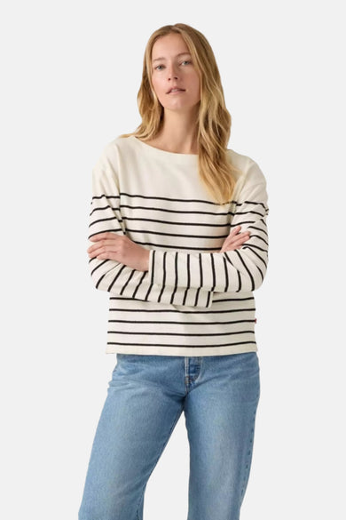 T-shirt à manches longues blanc à rayures noires de Levi's®, porté avec un jean bleu.
