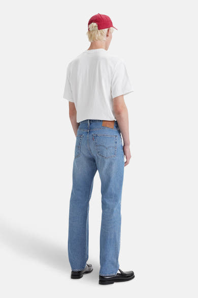Jean droit en denim bleu clair de Levi's®, porté avec un t-shirt blanc et des mocassins noirs.