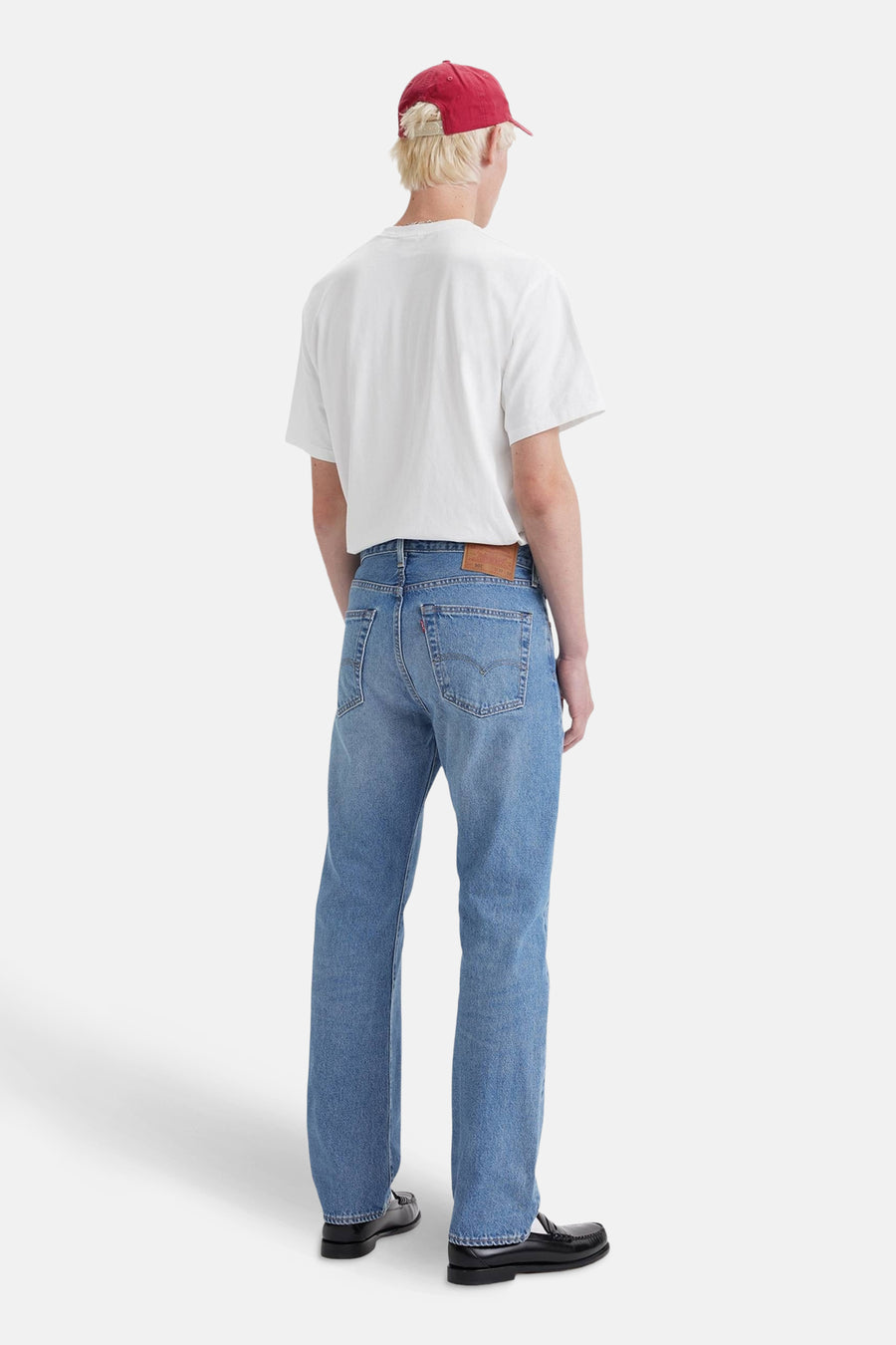 Jean droit en denim bleu clair de Levi's®, porté avec un t-shirt blanc et des mocassins noirs.