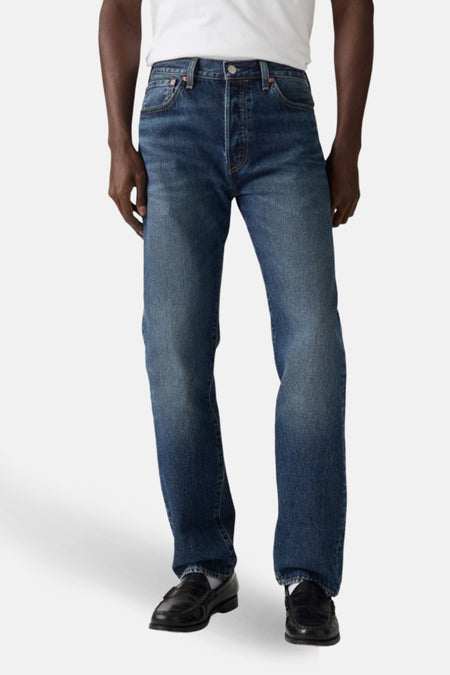 Jean droit en denim bleu foncé de Levi's®, porté avec des chaussures en cuir noir.