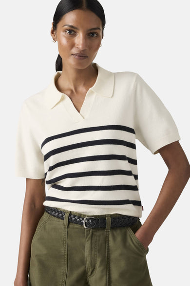 Pull blanc à rayures noires de Levi's®, porté avec un pantalon vert olive et une ceinture en cuir tressé.
