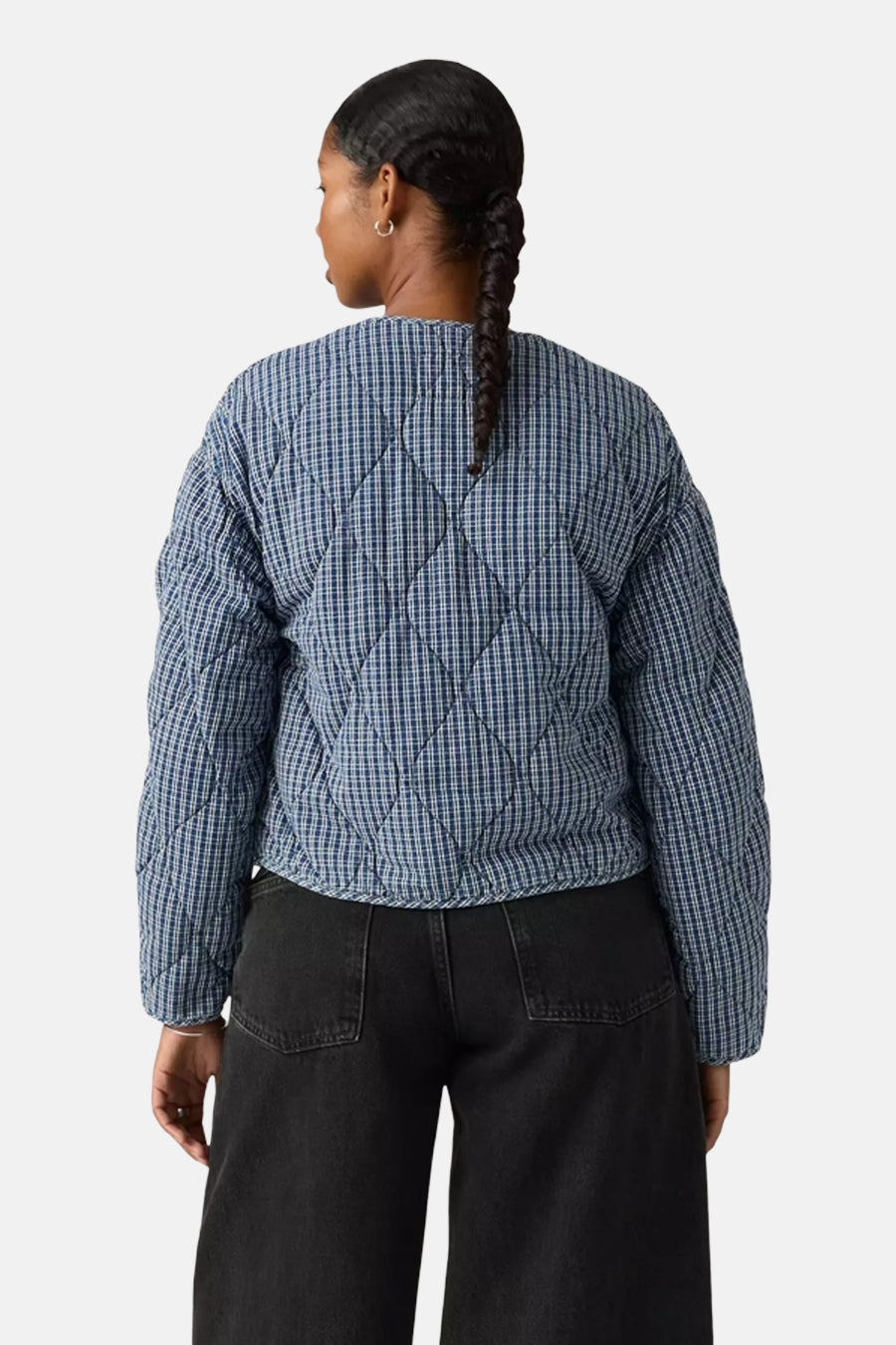 Veste courte bleue à carreaux, de Levi's®, avec un motif matelassé en losanges et un jean noir taille haute.
