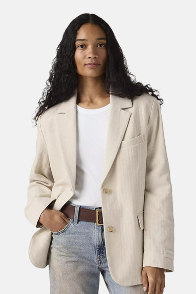 Blazer beige de Levi's® porté avec un t-shirt blanc et un jean, une main dans la poche.