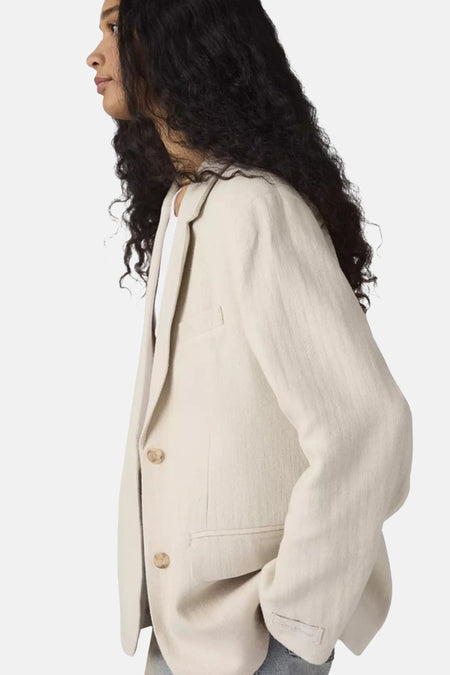 Beige blazer van Levi's, met twee knopen en een relaxte pasvorm, gedragen met een wit T-shirt.