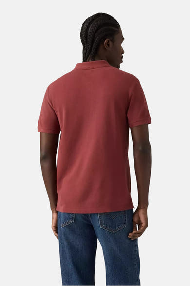 Polo bordeaux à manches courtes de Levi's®, vu de dos, porté avec un jean bleu classique.
