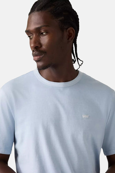 T-shirt bleu clair à manches courtes de Levi's, porté par un homme avec des tresses.
