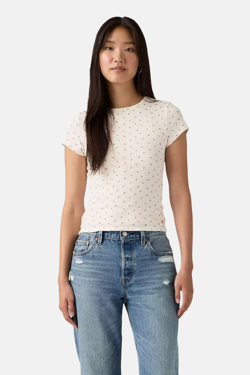 T-shirt blanc à manches courtes de Levi's, avec un motif fleuri, porté avec un jean bleu taille haute.
