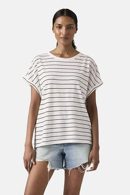 Wit T-shirt met korte mouwen en zwarte strepen van Levi's, gedragen met een lichtgewassen spijkerbroek en een zwarte riem.