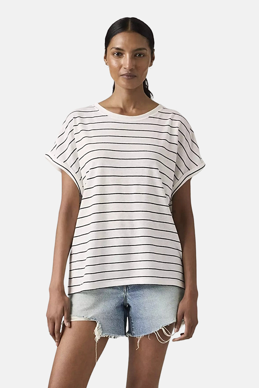 Wit T-shirt met korte mouwen en zwarte strepen van Levi's, gedragen met een lichtgewassen spijkerbroek en een zwarte riem.