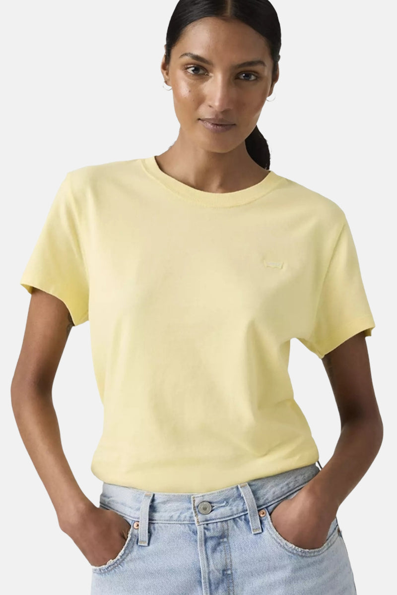 T-shirt jaune à manches courtes de Levi's, porté avec un jean taille haute.
