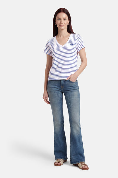 T-shirt multicolore à manches courtes de Levi's®, rayures blanches et bleues, porté avec un jean et des sandales.