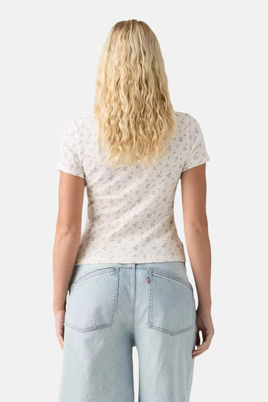 White short-sleeve T-shirt with delicate floral print, back view on model wearing light wash jeans