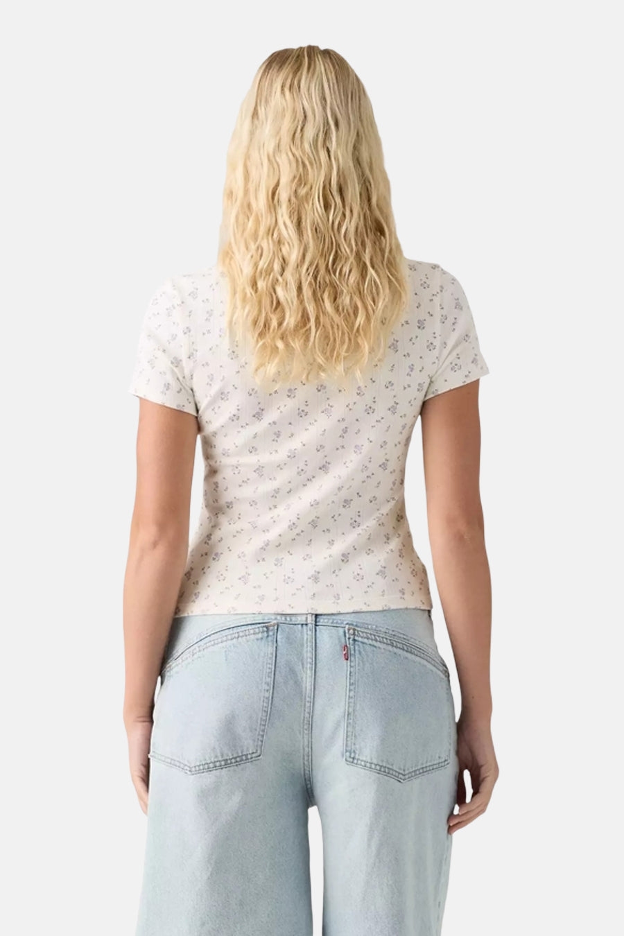White short-sleeve T-shirt with delicate floral print, back view on model wearing light wash jeans