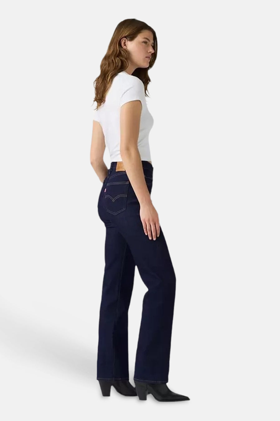Dark blue straight-leg jeans by 723, side view, featuring classic stitching and back pocket detail, worn with white top and black boots
