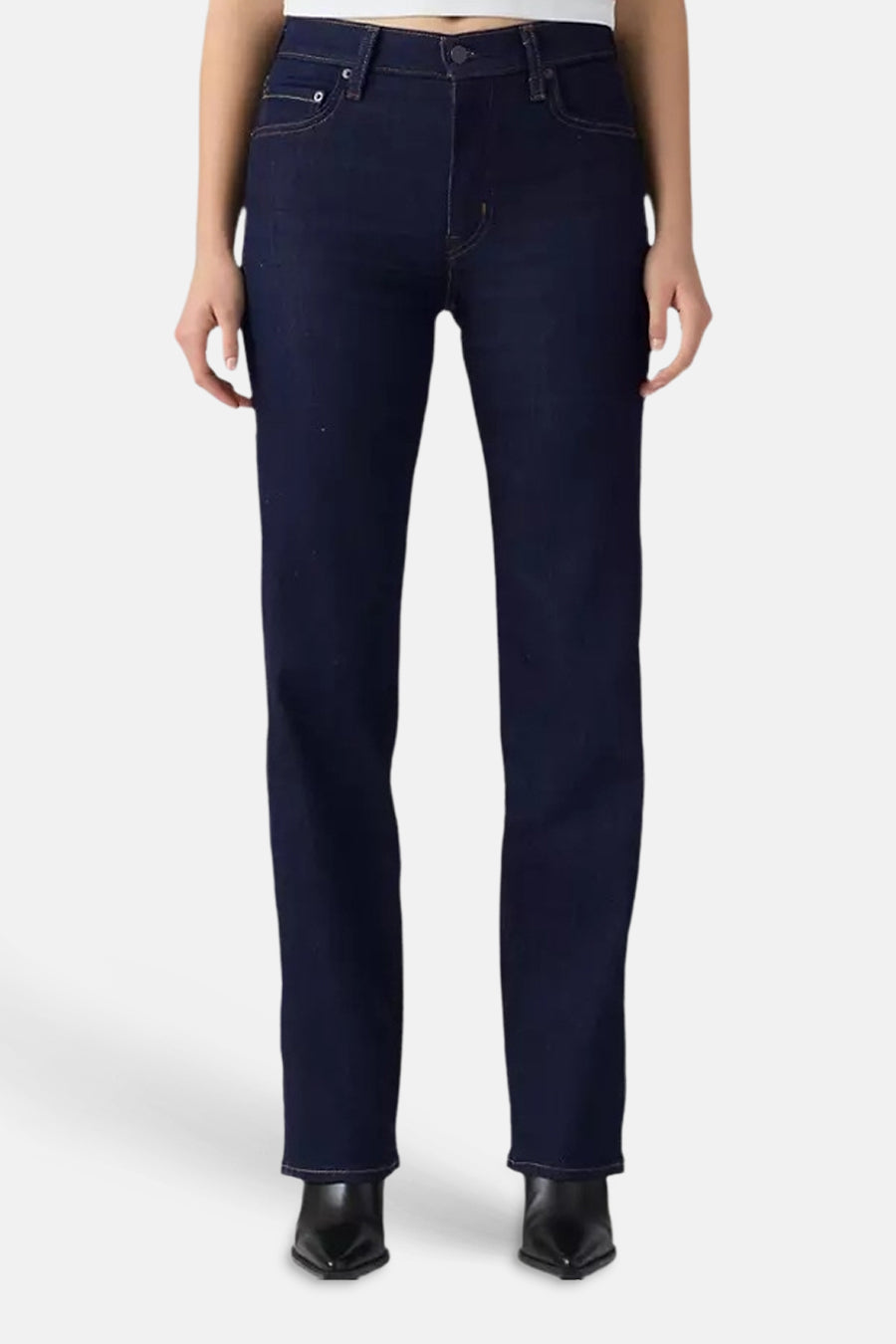 Dark blue straight-leg jeans with classic five-pocket design, front view, worn with black pointed boots