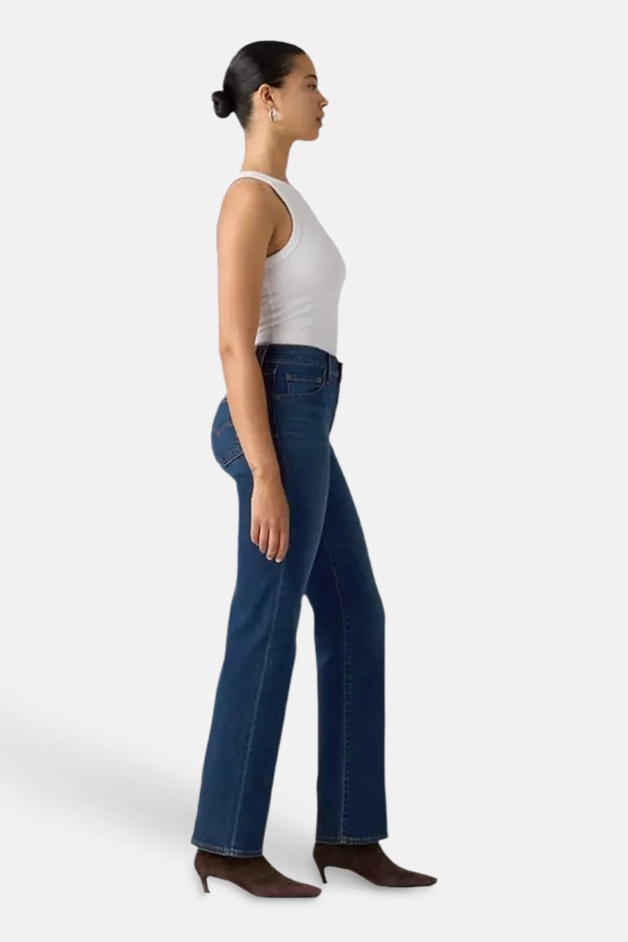 Dark blue straight-leg jeans by 723, side view, worn with white tank top and brown heeled boots