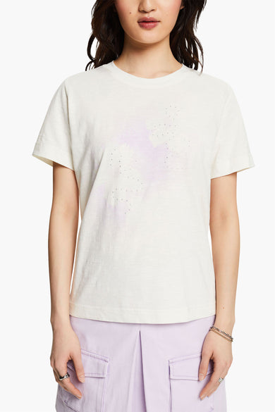 T-shirt écru à manches courtes de Esprit, motif étoile délavé avec strass, porté avec un pantalon violet.