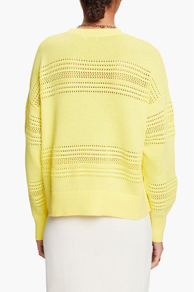 Gele rondehals trui van Esprit, met ajourdetails, gedragen met een witte rok.