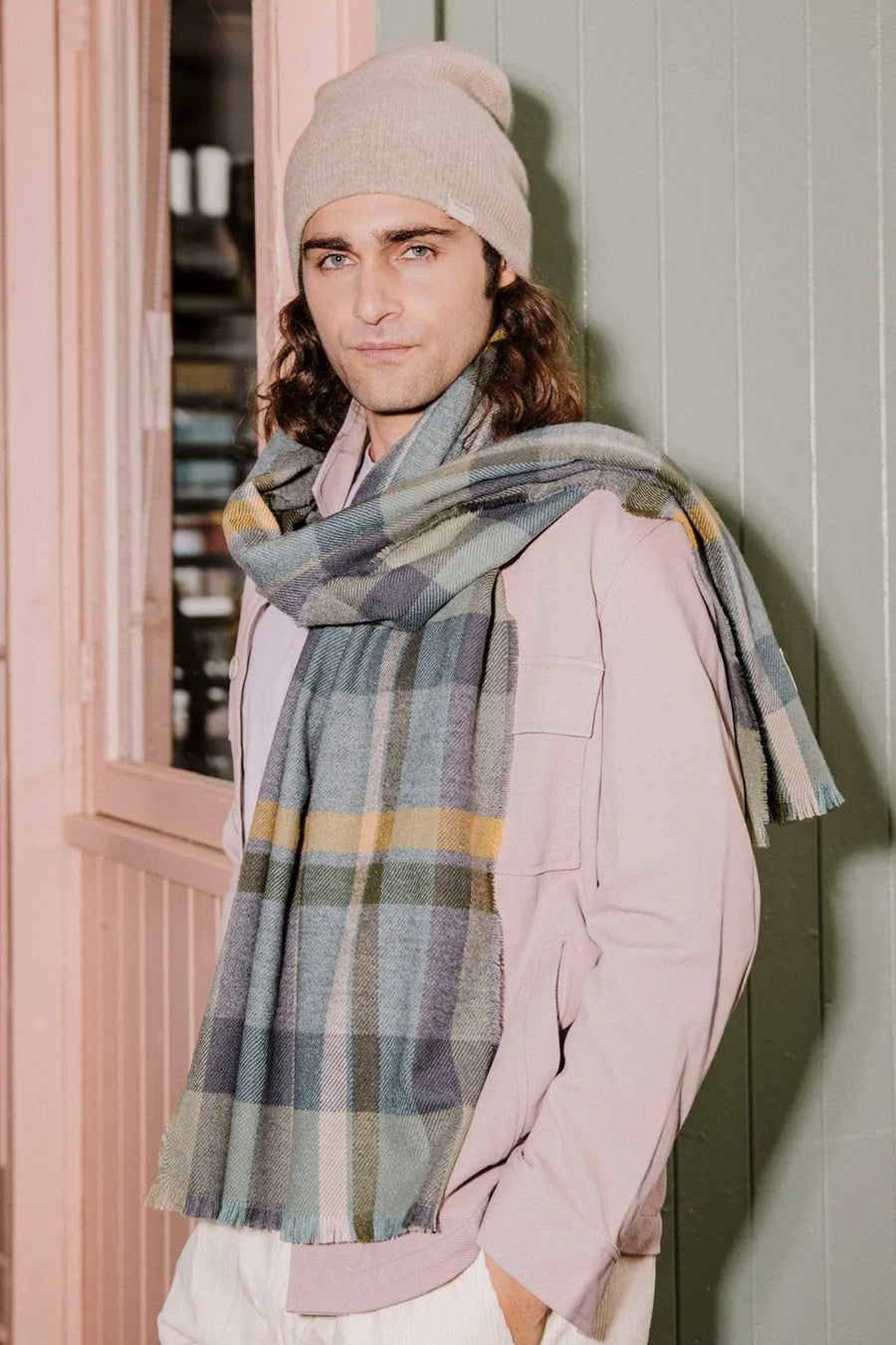 Foulard vert à carreaux by BARTS, porté autour du cou avec un bonnet beige et une veste rose.