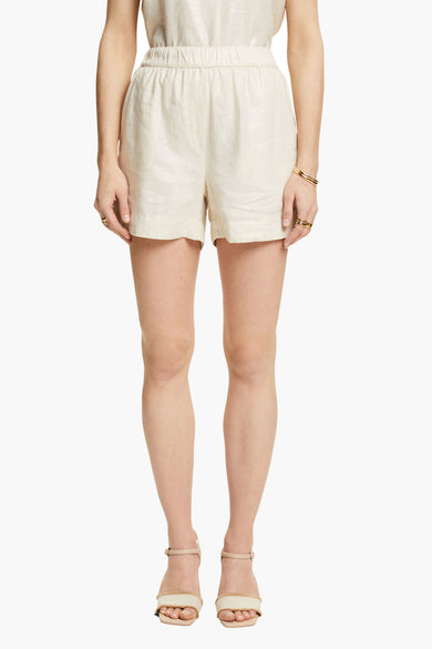 Short beige Esprit avec une taille élastiquée, porté avec des sandales à talons nude.