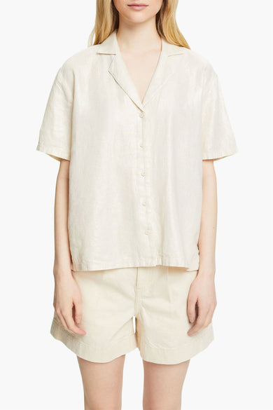 Chemise beige à manches courtes par Esprit, tissu texturé avec fermeture boutonnée, portée avec un short coordonné.