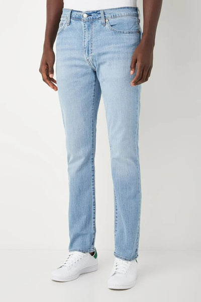 Jean slim en denim bleu clair de Levi's, coupe décontractée, porté avec des baskets blanches.
