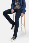 Slim jeans in donkerblauw denim van Levi's, gedragen met een gestreept T-shirt en een groene pet.