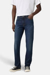Slim jeans in donkerblauw denim van Levi's®, gedragen met een wit T-shirt en zwarte schoenen.