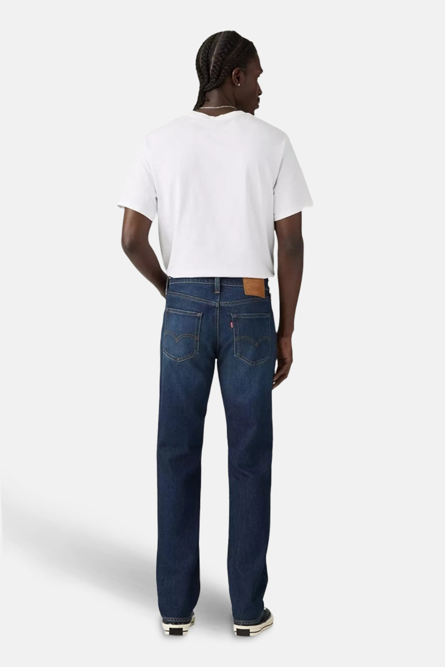 Jean slim en denim bleu foncé de Levi's®, porté avec un t-shirt blanc et des chaussures noires.