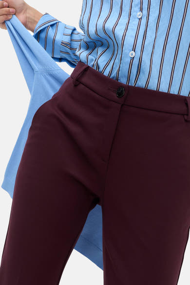 Chino rouge foncé BRAX porté avec une chemise bleue à rayures verticales
