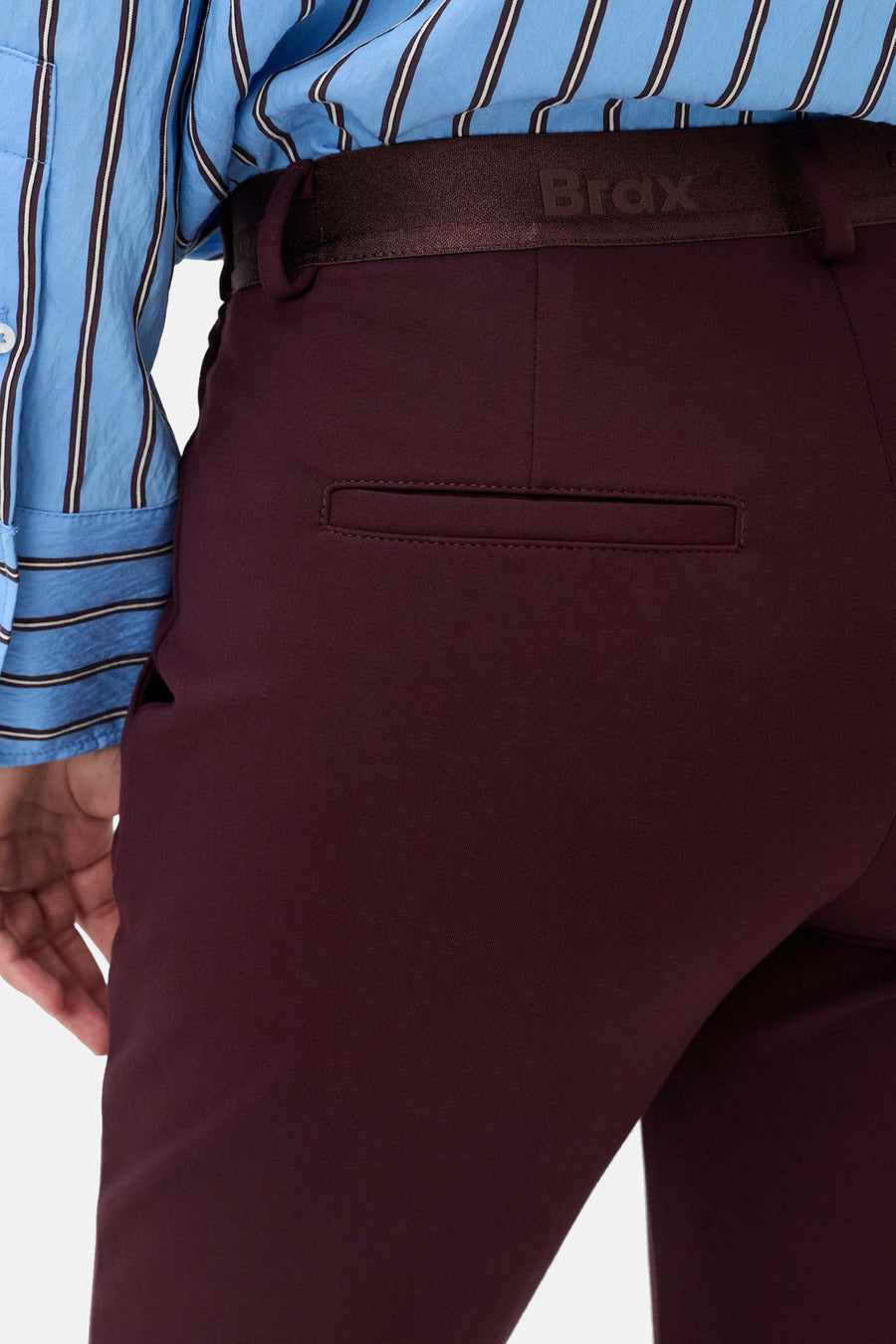 Détail d’un chino rouge foncé BRAX porté, avec poche arrière passepoilée visible.