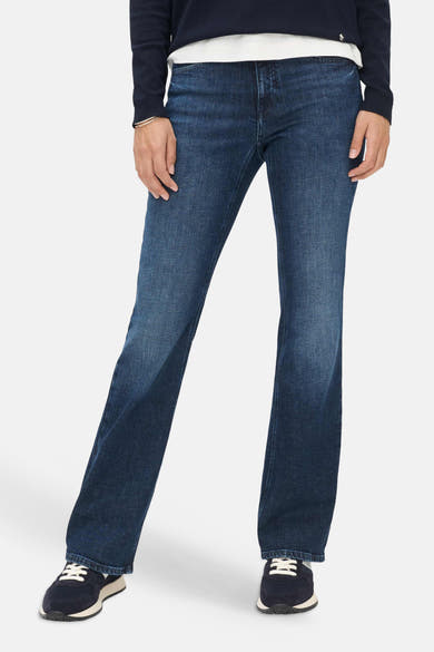 Mid blue denim bootcut jeans by BRAX, featuring a relaxed fit with subtle fading and straight legs, shown on model with navy sweater and sneakers.