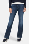Mid blue denim bootcut jeans by BRAX, featuring a relaxed fit with subtle fading and straight legs, shown on model with navy sweater and sneakers.