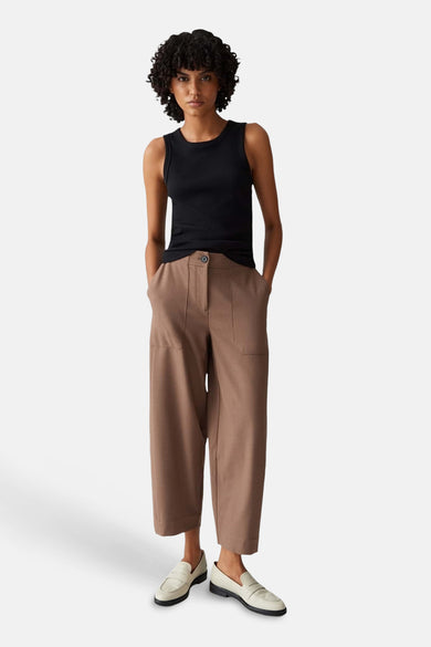 Top sans manches noir côtelé d'OPUS, porté par un modèle avec un pantalon marron et des mocassins clairs.