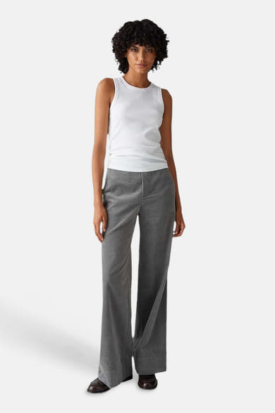 Top blanc de OPUS, en maille côtelée, porté avec un pantalon gris et des chaussures marron.