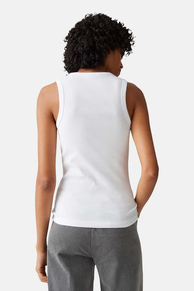 Top blanc côtelé sans manches de OPUS, vue de dos, porté avec un pantalon gris.