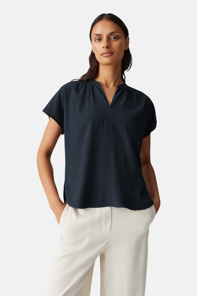 Donkerblauwe blouse met korte mouwen van OPUS, met opstaande kraag en kreuktextuur.