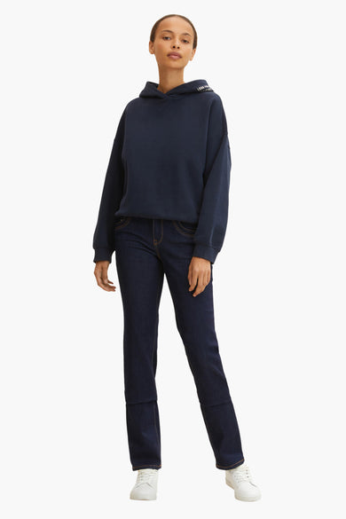 Jean droit bleu foncé de Tom Tailor, porté avec un sweat à capuche bleu marine et des baskets blanches.

