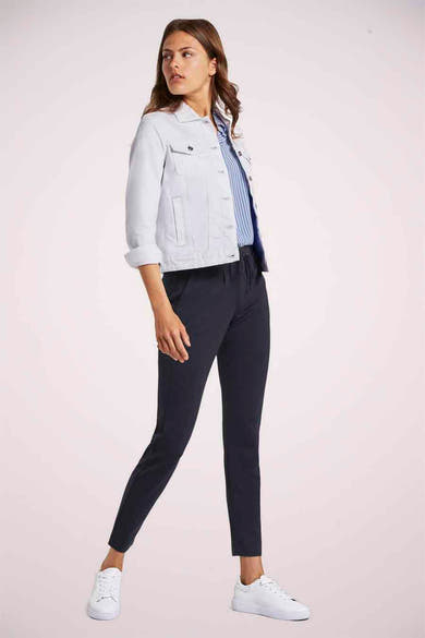 Pantalon coloré bleu marine de Tom Tailor, porté avec une veste en jean et des baskets blanches.