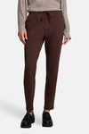 Brown five-pocket women's trousers with drawstring waist, front view, paired with polka-dot blouse and black loafers
