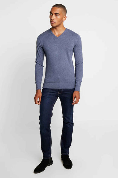 Pull bleu col V de Tom Tailor, porté avec un jean bleu foncé et des bottines noires en daim.