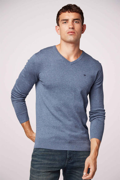 Pull bleu à col en V par Tom Tailor, porté avec un jean foncé.