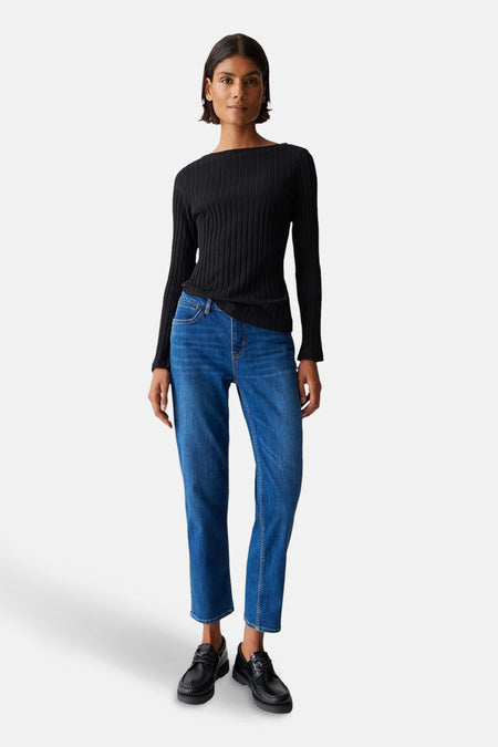 Pull à col rond noir de OPUS, porté avec un jean bleu et des chaussures noires.
